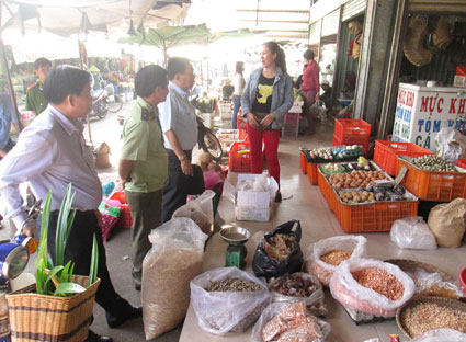 Đoàn kiểm tra nhắc nhở tiểu thương vấn đề ATVSTP và PCCC tại chợ Kim Long. Ảnh: THU THẢO